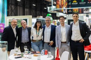 Grupo de seis personas posando juntas en el stand de Ràfols durante una feria comercial.