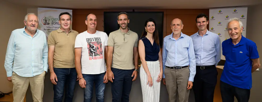 Grupo de ponentes de una jornada de Mercabarna posando de pie en una sala de conferencias tras la mesa redonda.