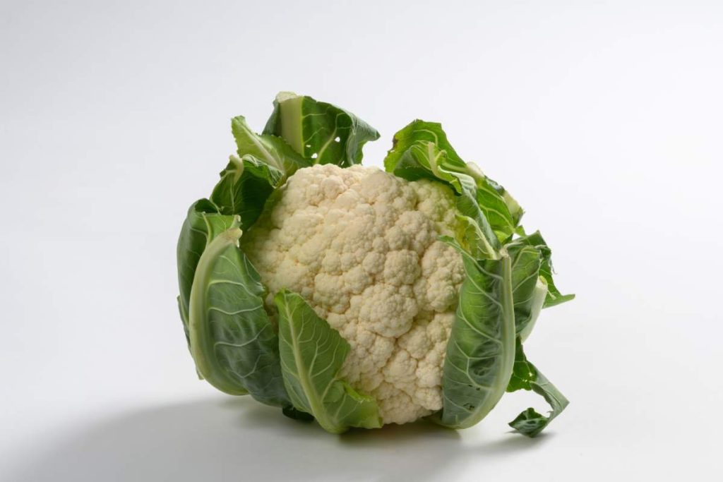 Coliflor blanca con hojas verdes.