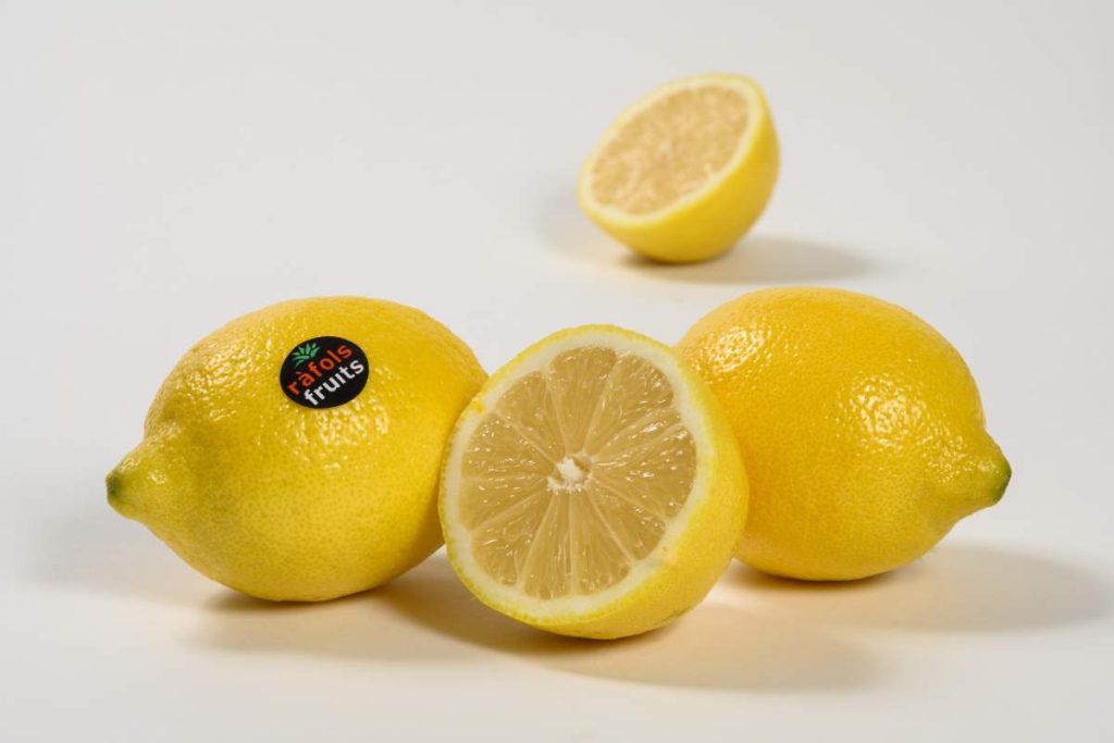 Dos limones enteros y dos mitades, uno con la etiqueta de Fruits Ràfols.